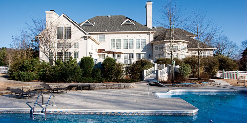 Backyard of traditional European mansion by Glenn Cope Custom Home Builders