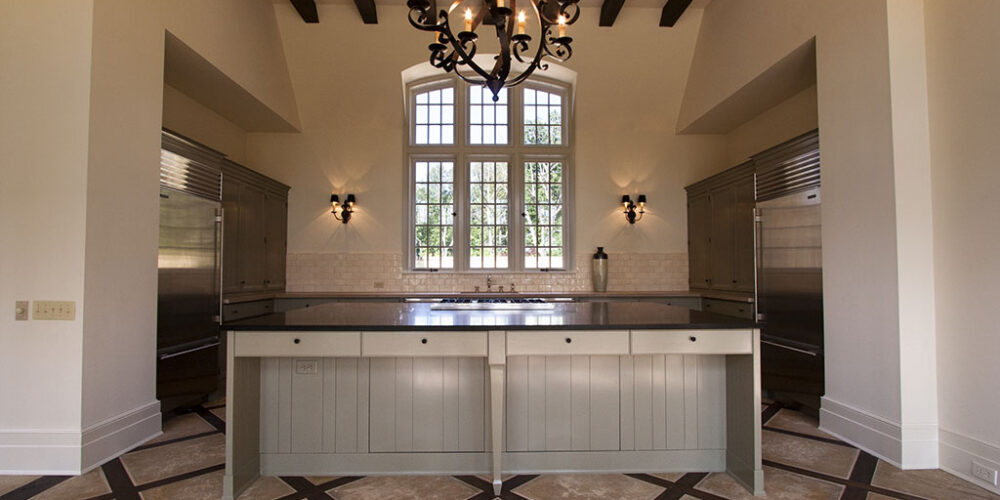Professional kitchen with large island and intricate tile pattern by Glenn Cope Custom Home Builders