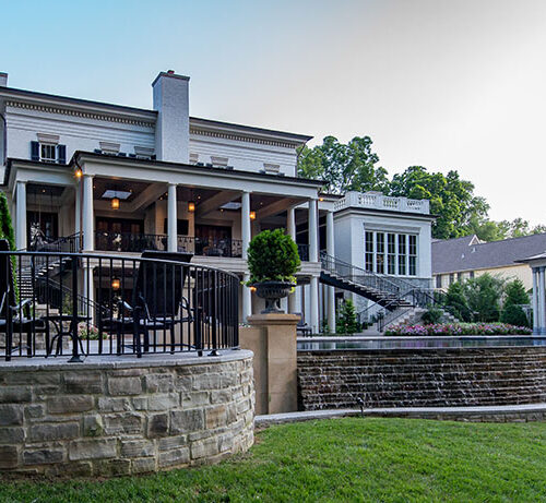 Terrace backyard to Greek Revival styled home by Glenn Cope Custom Home Builders