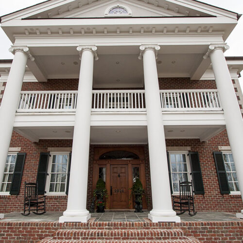 Front porch and balcony of Greek Revival styled home by Glenn Cope Custom Home Builders
